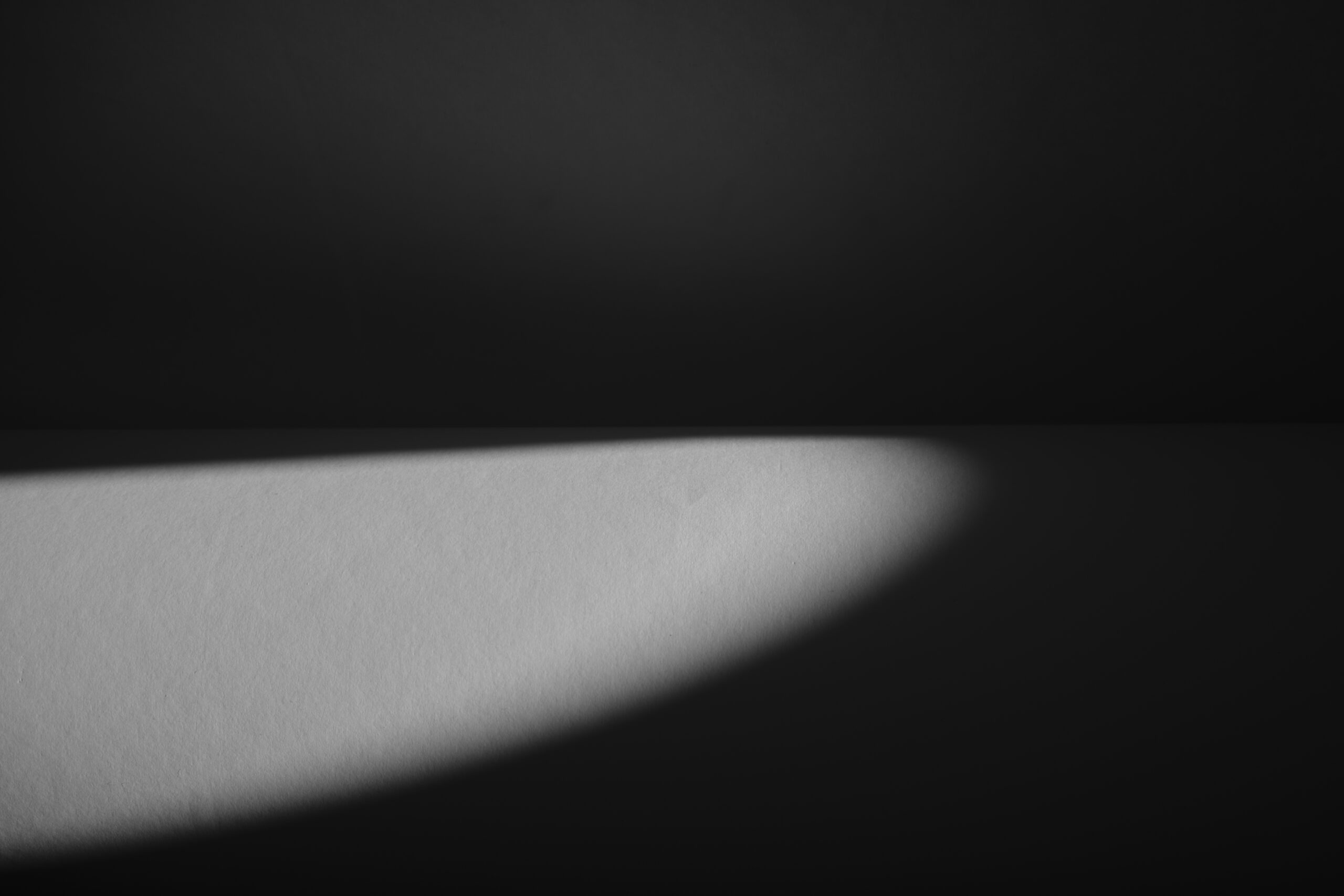 Liggende foto met liggende lichte ovaal op zwarte achtergrond.