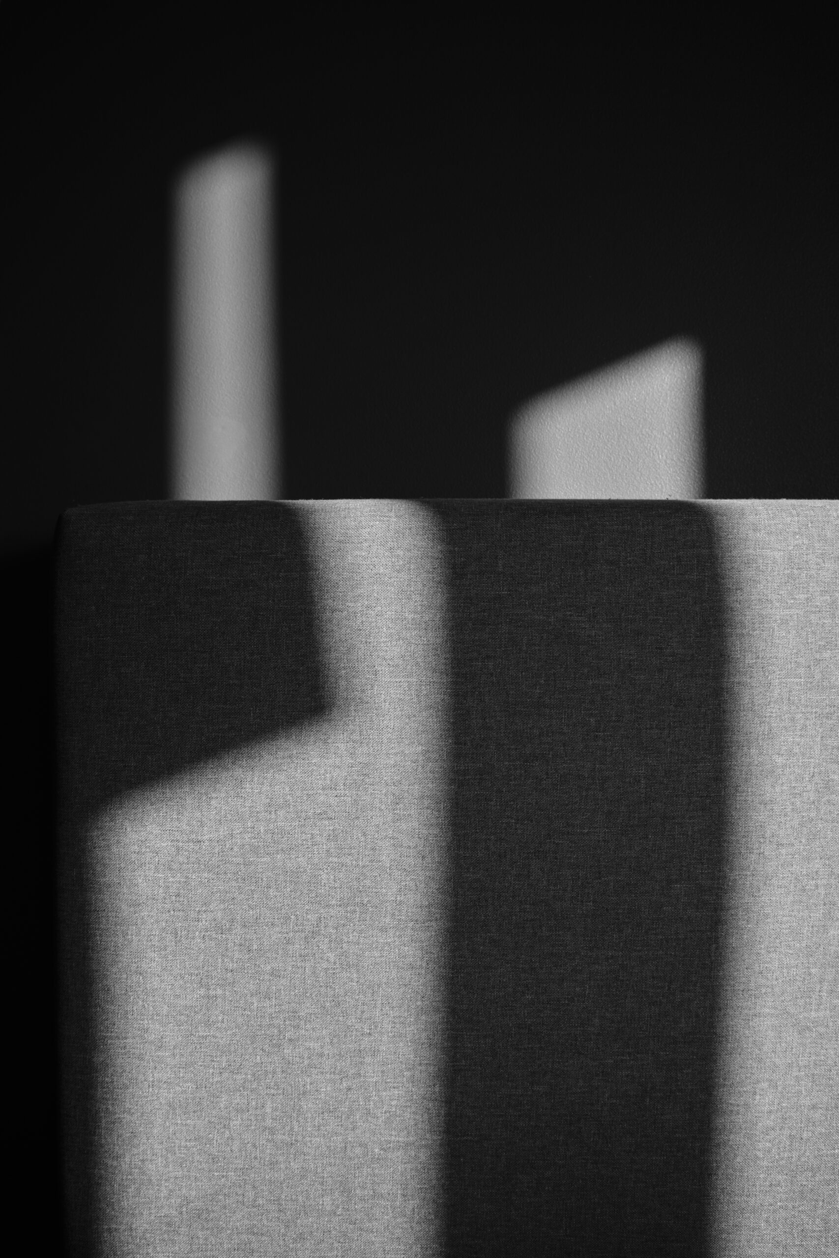 Schaduw in rechthoekige vormen licht grijs, rest is donker bijna zwart.