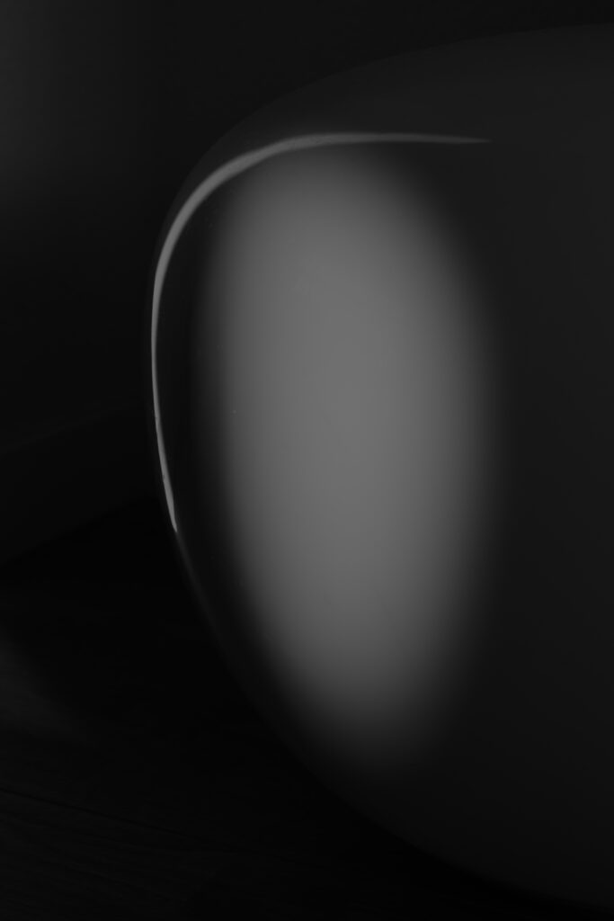 Ovale grijze vorm op zwarte achtergrond.